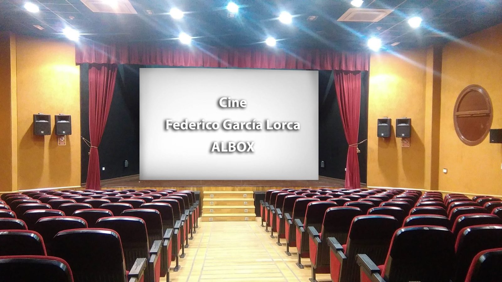 Sala del cine Federico García Lorca de Albox, con el escenario, la pantalla y las butacas rojas