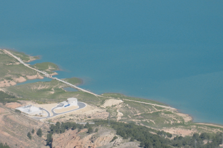 Vista aérea de un embalse con unas instalaciones hidráulicas en la orilla