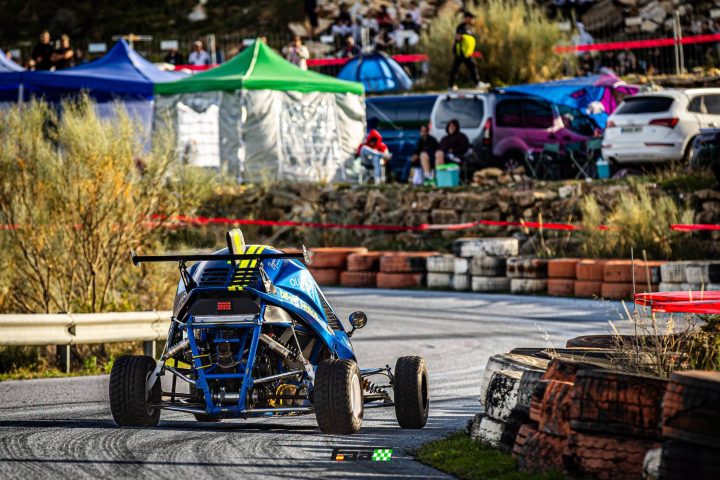 Car cross azul en una curva de la Subida del Mármol, con público al fondo