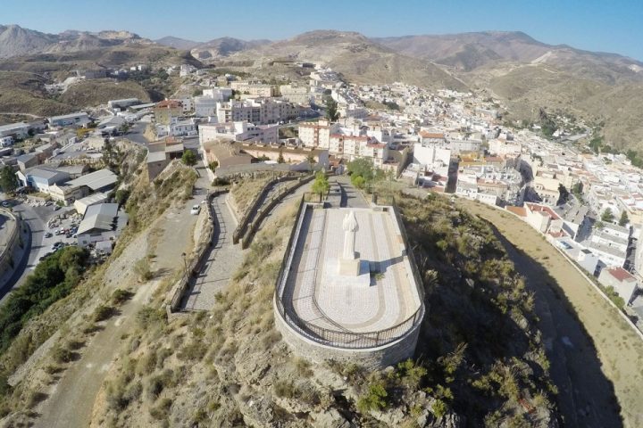 Vista aérea de Macael, con un monumento en primer plano y la sierra al fondo