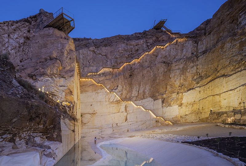 Escaleras iluminadas y miradores sobre la cantera del Parque Minero de Macael al anochecer
