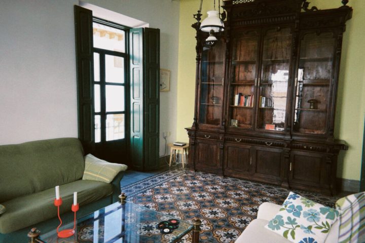 Salón de Picassa Coliving en Purchena, con una vitrina antigua de madera y suelo hidráulico
