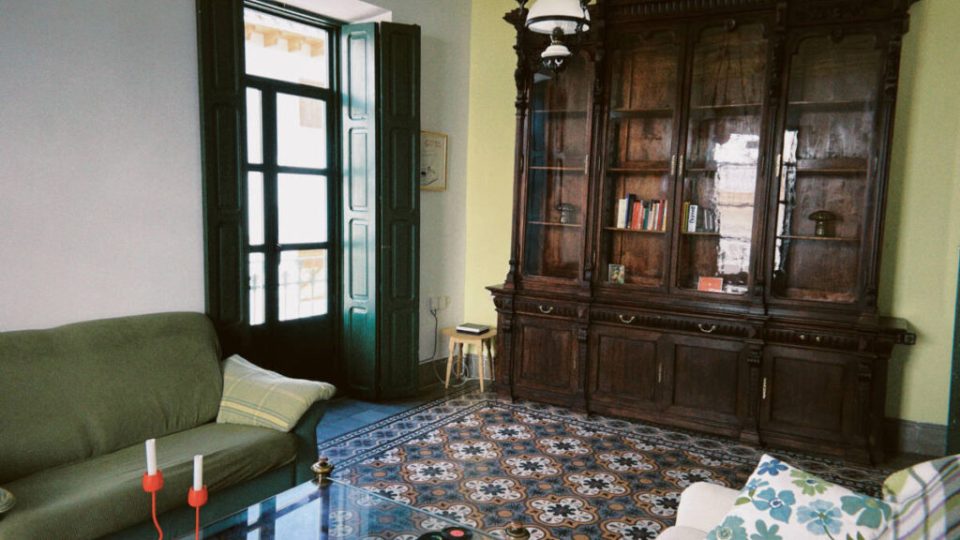 Salón de Picassa Coliving en Purchena, con una vitrina antigua de madera y suelo hidráulico