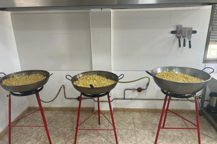 Tres paelleras con migas de harina al fuego en el obrador de Migas de Taberno