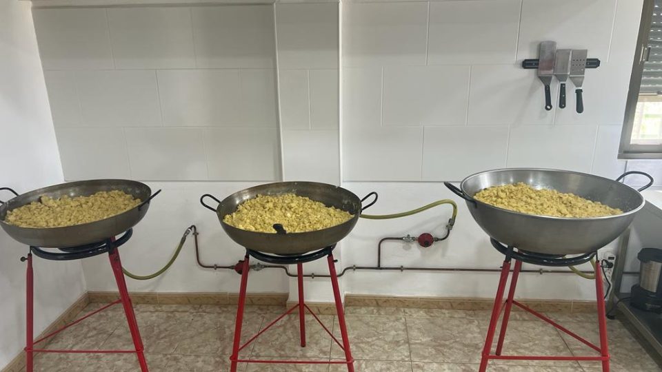 Tres paelleras con migas de harina al fuego en el obrador de Migas de Taberno